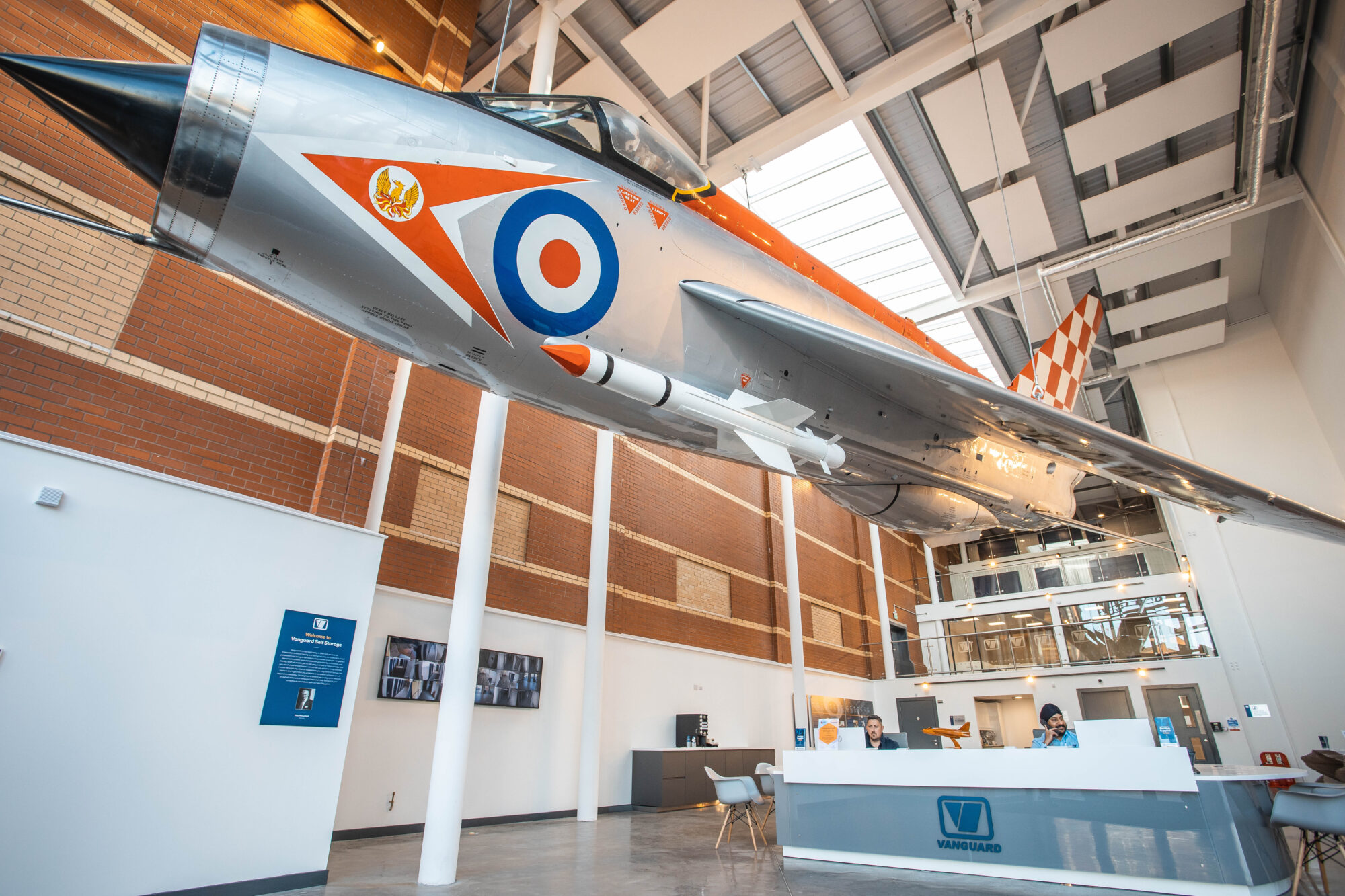 An interior shot of Vanguard's Bristol branch showcasing the fully restored English Electric Lightning fighter jet plane hanging in the reception.