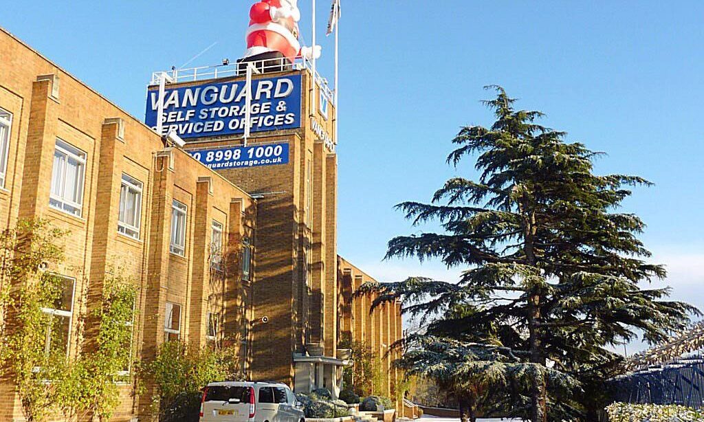A photo of a giant Santa Claus on top of the roof of Vanguard Self Storage's branch in West London.