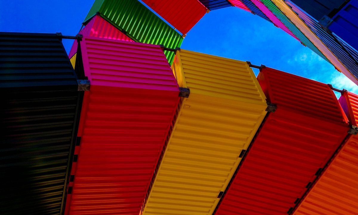 A photo showing colourful storage containers with a clear blue sky.