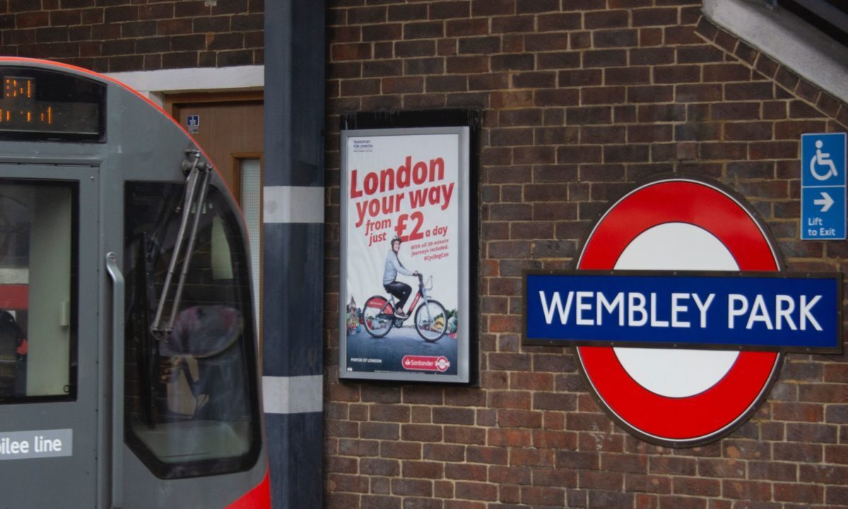 A photo showing a tube train pulling in to the Wembley Park underground station.