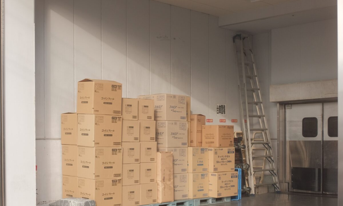 A photo showing a self-storage unit filled with cardboard boxes stacked on several pallets.