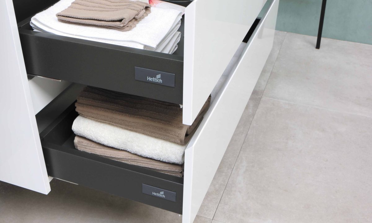 A photo of organised drawers with folded clothes and blankets.