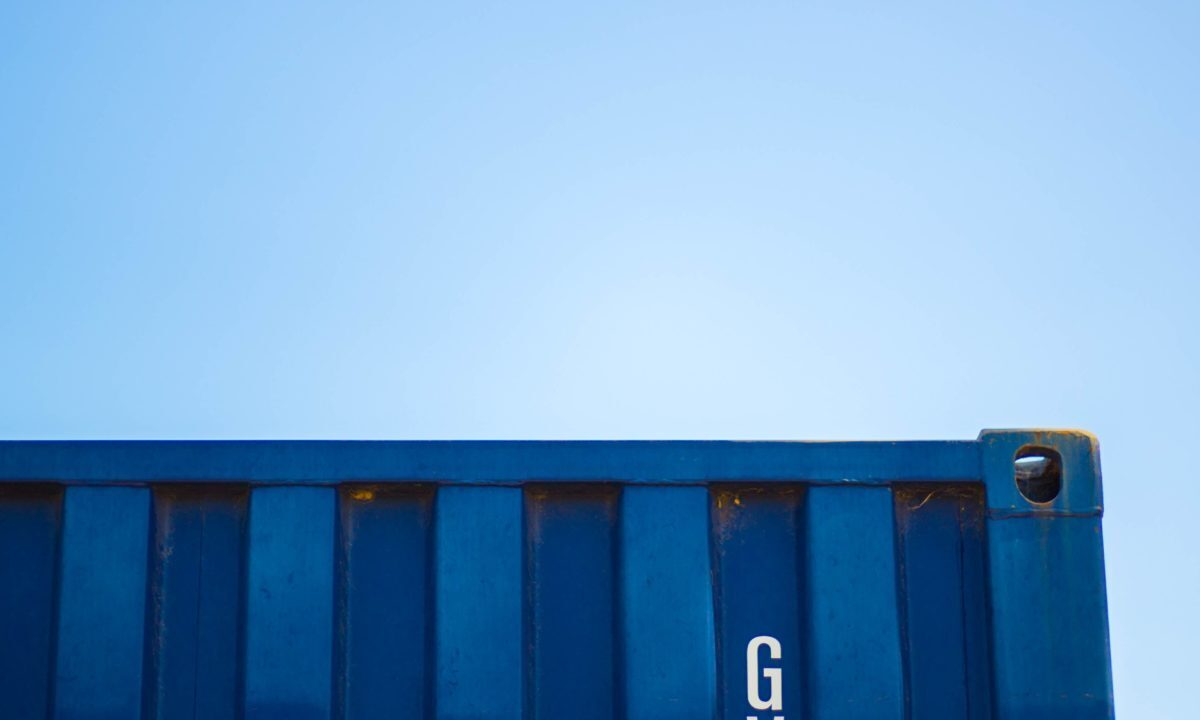 A photo showing the corner of a container storage against a clear blue sky.