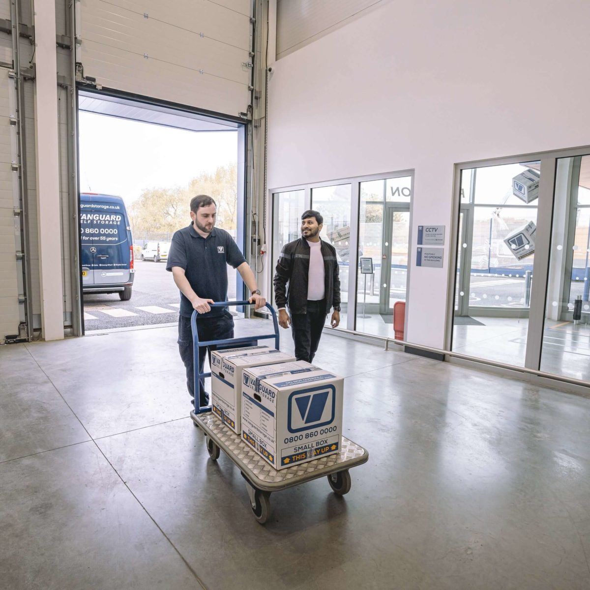 A photo showing a Vanguard employee helping a customer move his boxes into one of the Vanguard Self Storage units.