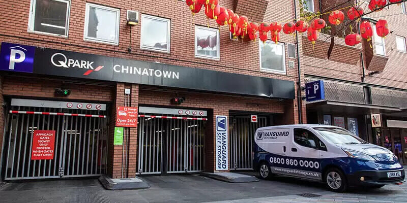A photo of the exterior of QPark in Chinatown, with the Vanguard van packed just outside.