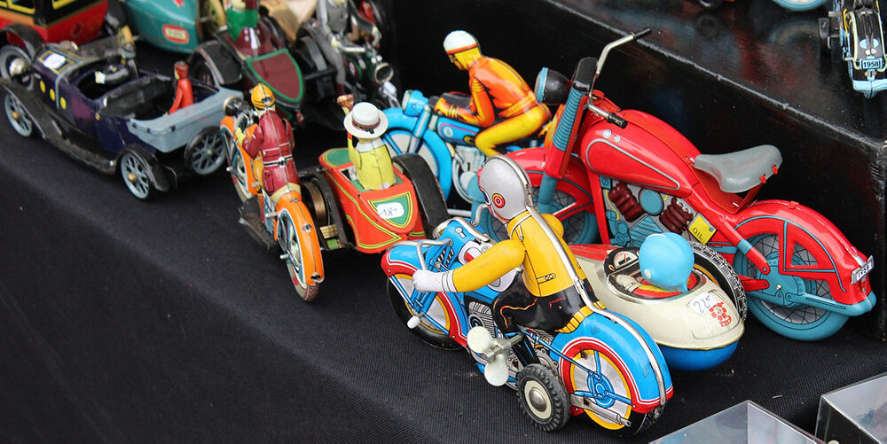 A photo showing a group of small collectible toys, including models of cars and motorbikes.