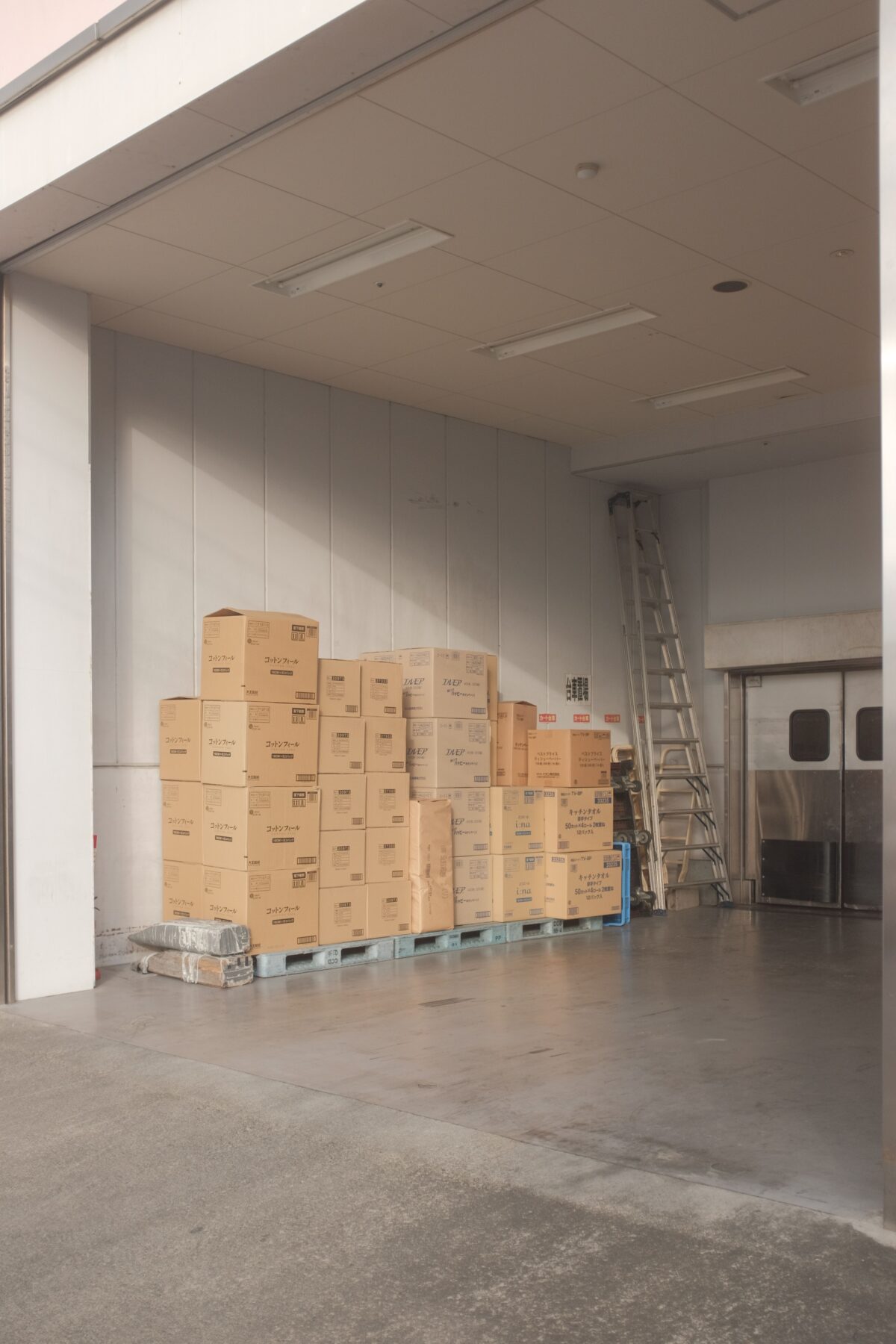 A photo showing a self-storage unit filled with cardboard boxes stacked on several pallets.