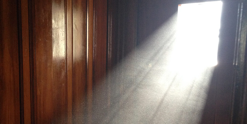 A photo showing sunlight shining in a dark brown room.