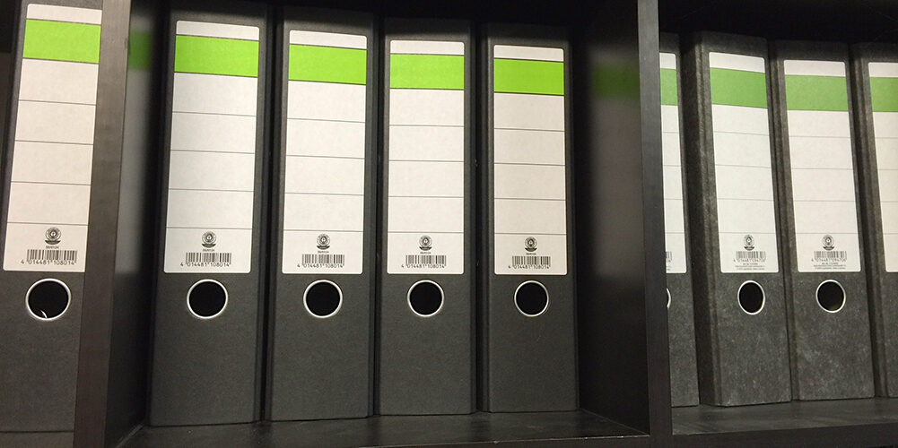 A photo showing trading card binders on a shelf.