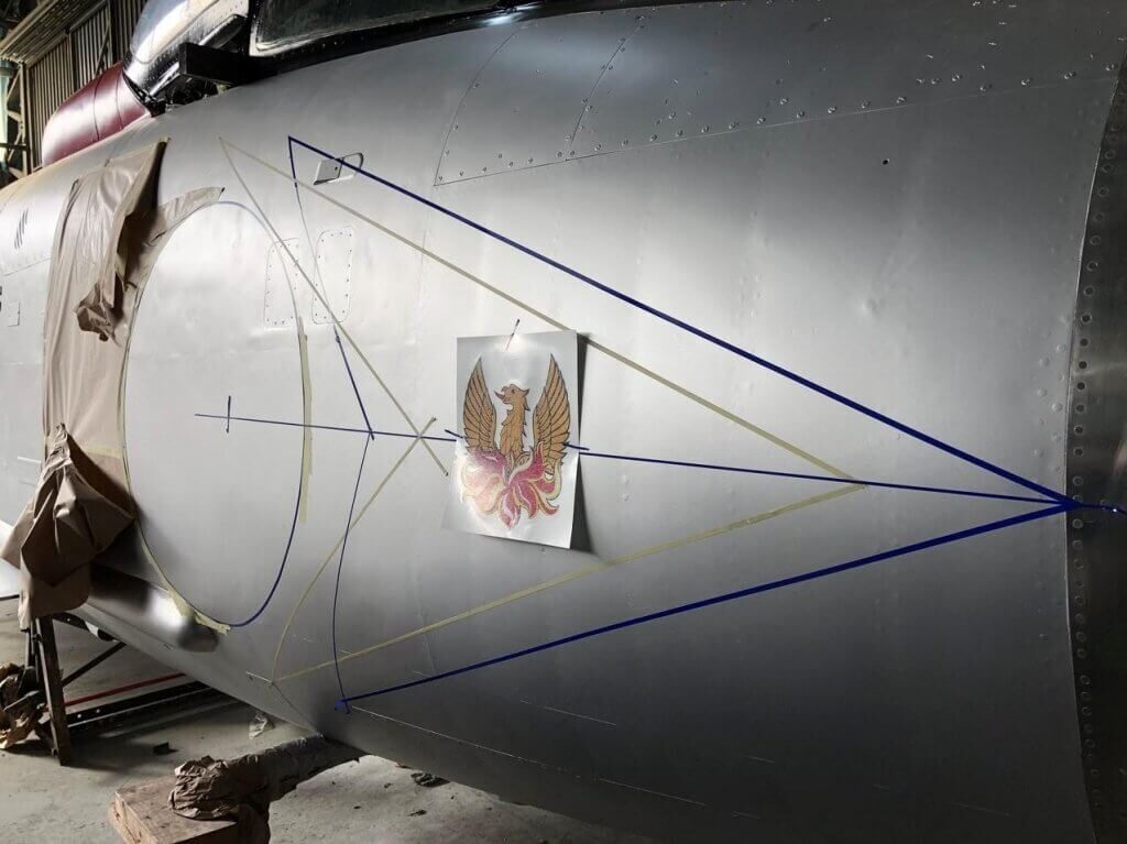 A photo showing the restoration process of the fighter jet hanging in the Vanguard Staples Corner branch.