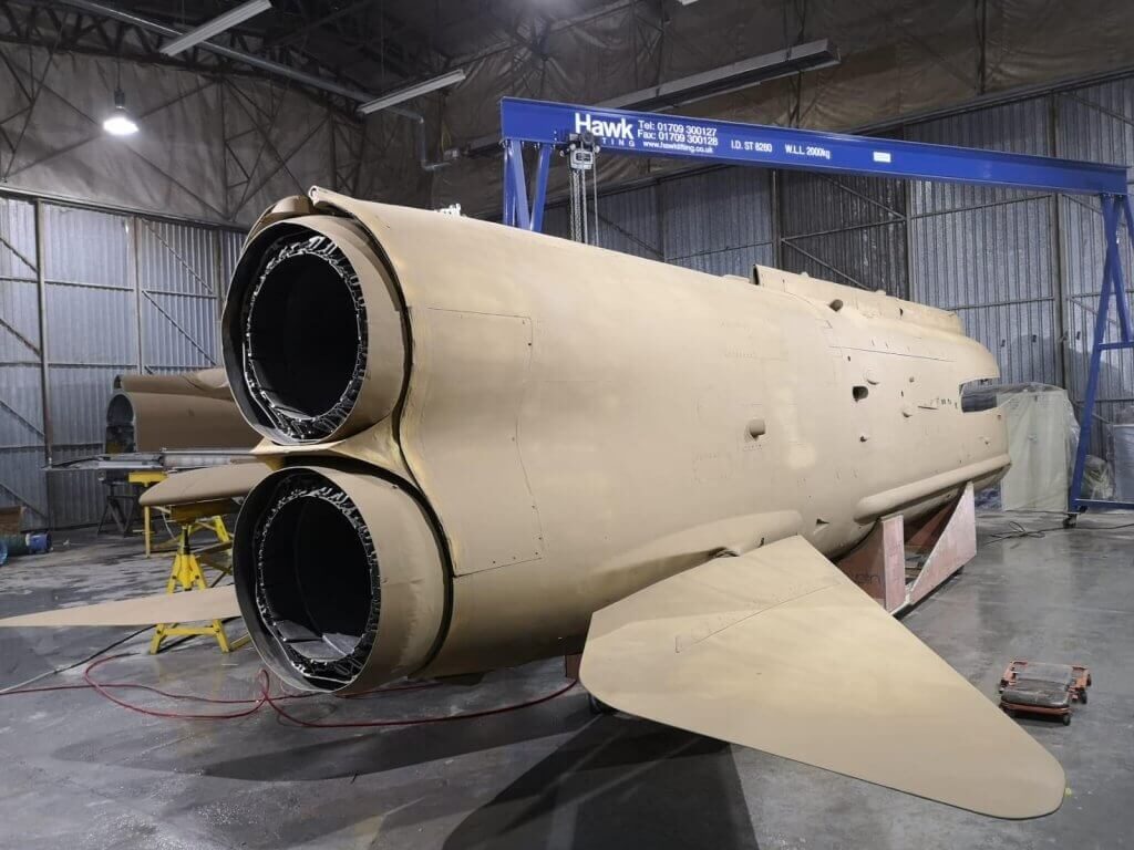 A photo showing the restoration process of the fighter jet hanging in the Vanguard Staples Corner branch.