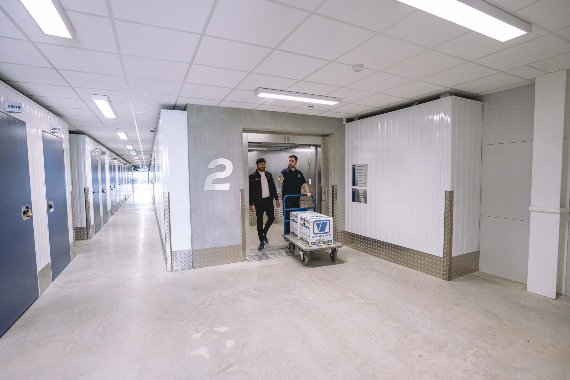 A photo showing a Vanguard employee helping a customer move his boxes into one of the Vanguard Self Storage units.