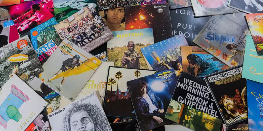 A photo showing a large number of music vinyls spread on a table.