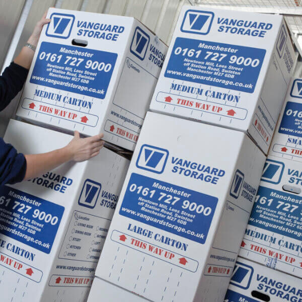 A photo showing a person stacking up Vanguard's cardboard boxes.